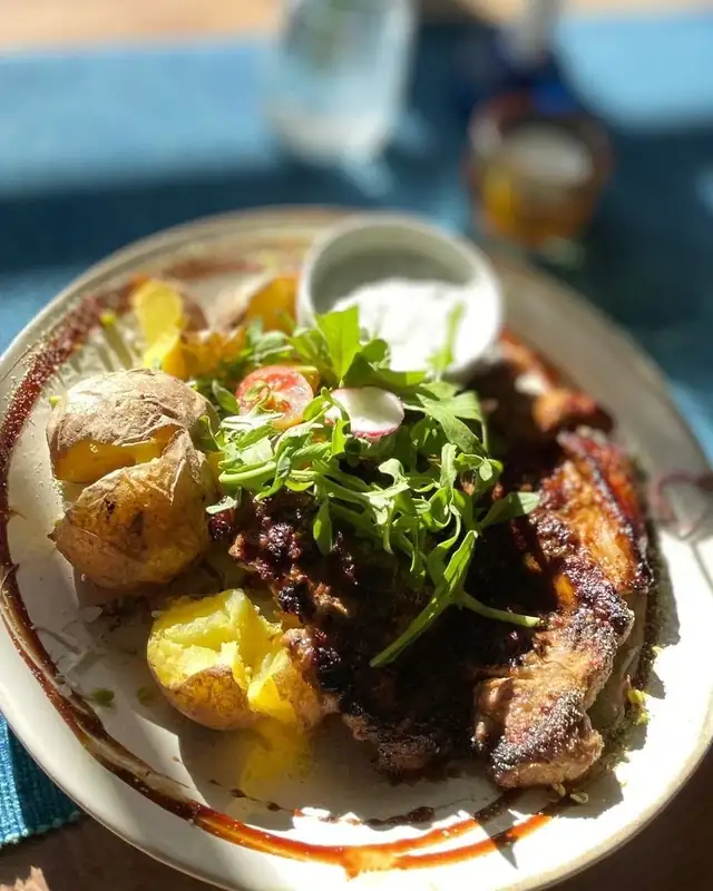 Danie z grillowanym mięsem, ziemniakami i sałatą na talerzu